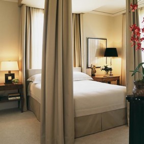 chambre beige avec un lit près de la fenêtre