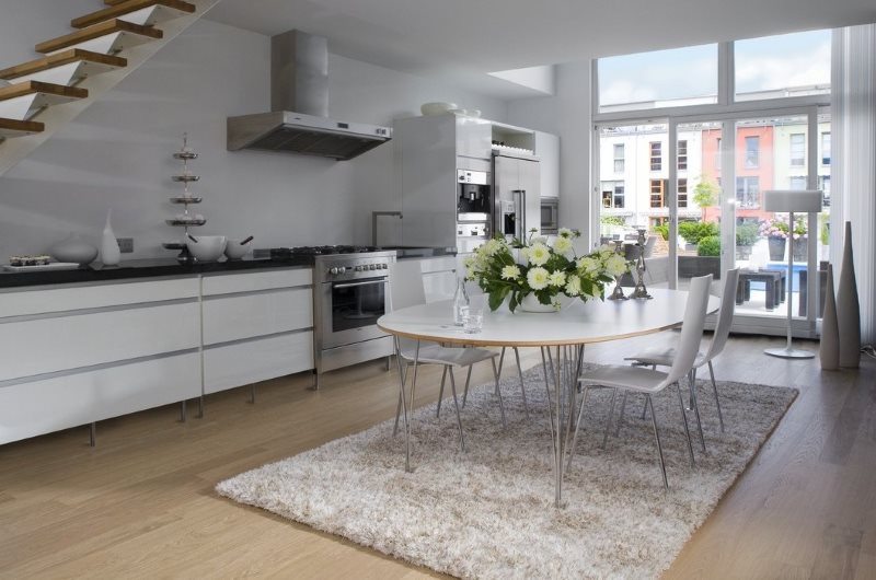 Alfombra gris con una larga pila en la cocina con una gran ventana