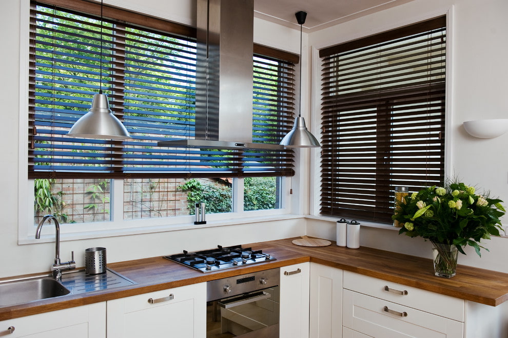 Jaluzelele orizontale întunecate pe geamurile bucătăriei