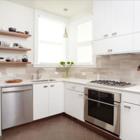 Muebles blancos en la cocina con ventanas de esquina.
