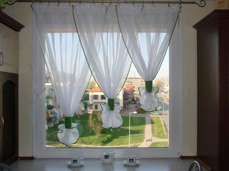 Korte tule gordijnen op het keukenraam