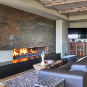 Canapea gri în fața unui șemineu cu gaz