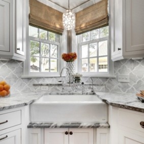 Un évier dans le coin de la cuisine avec des fenêtres donnant sur la cour