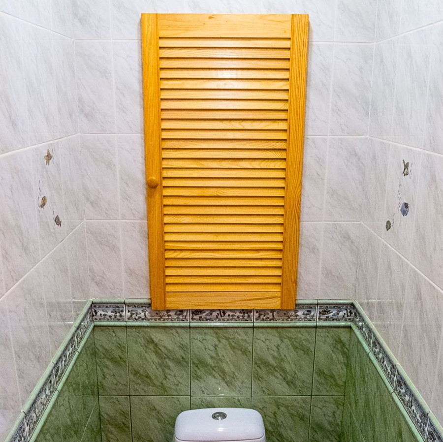 Stores en bois dans les toilettes d'un petit appartement