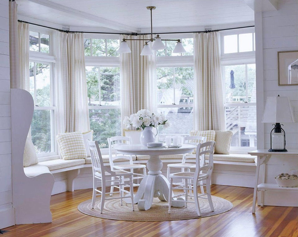 Table ronde blanche dans la baie vitrée du salon