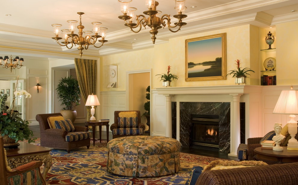 Twee kroonluchters op het plafond van de hal met open haard