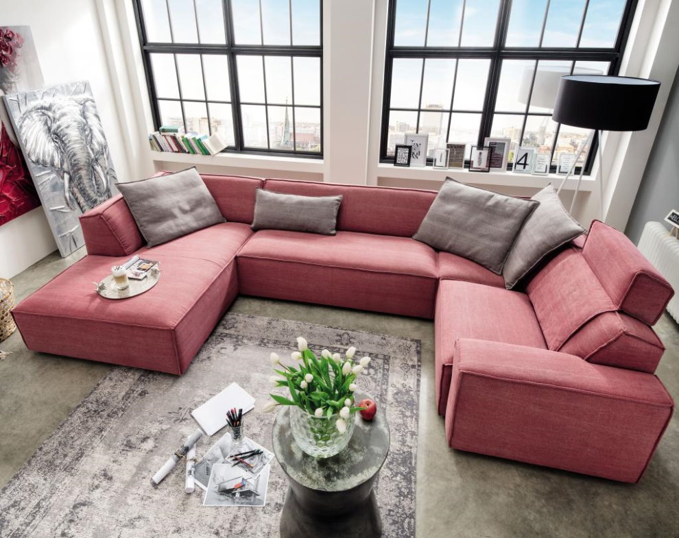 Диван с форма на С в залата с два прозореца