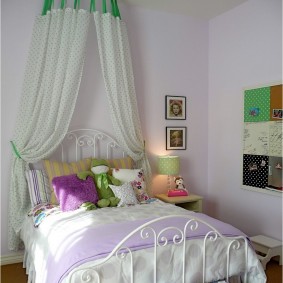 A bed on a metal frame in the bedroom of the girl