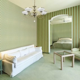 Λευκός καναπές κοντά στον τοίχο της αίθουσας με ταπετσαρία