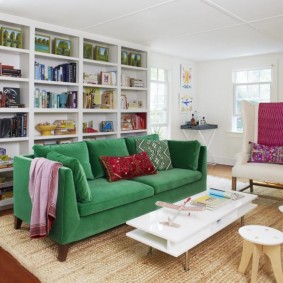 ชั้นวางของสีขาวด้านหลังโซฟาสีเขียว