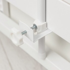 Fixing the canopy on the lower rail of the crib