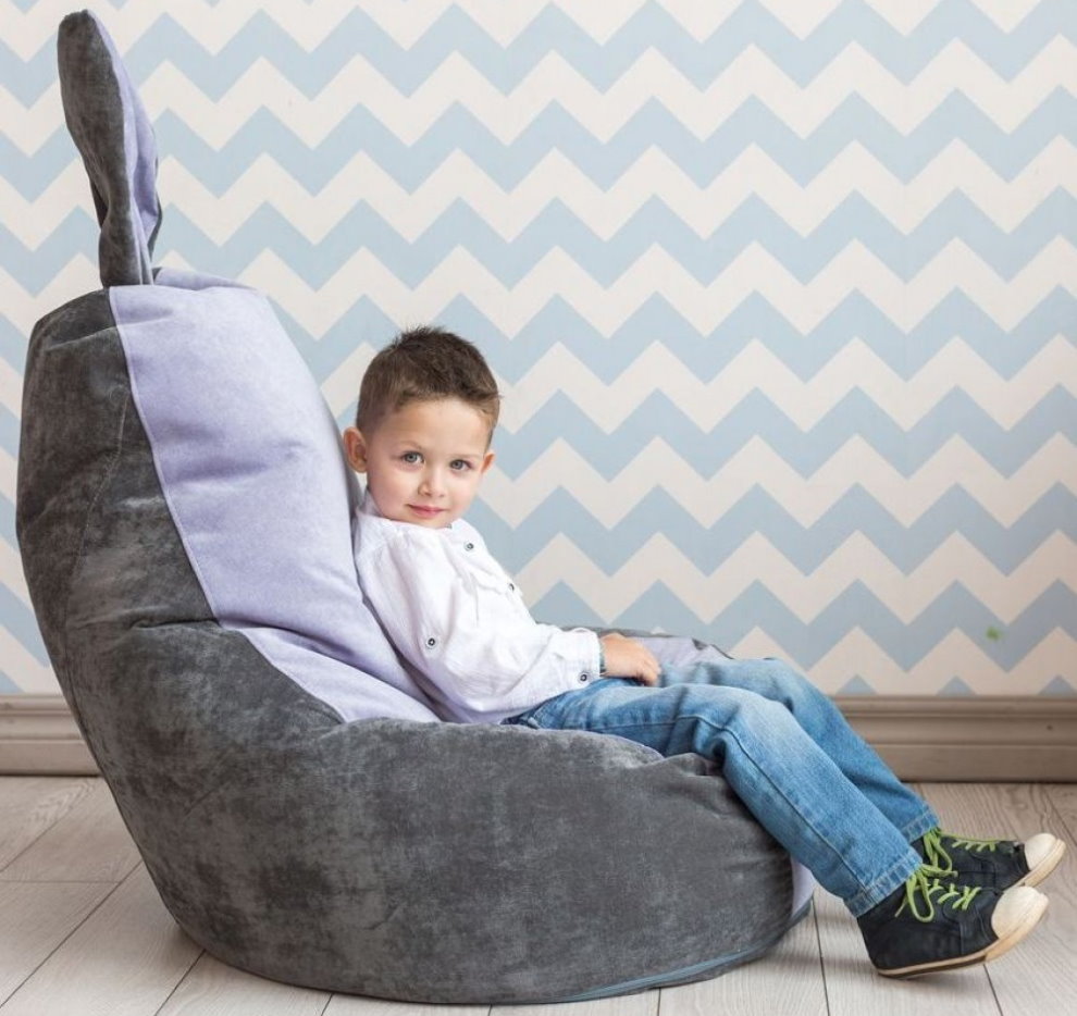 Μικρό αγόρι σε καρέκλα χωρίς σκελετό με αυτιά