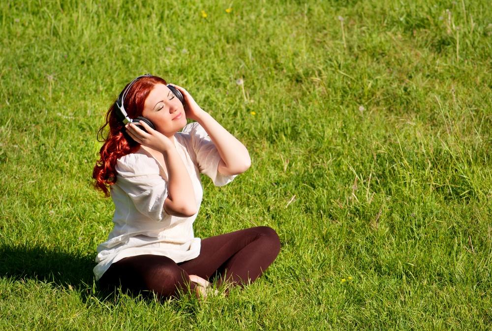 Fille au casque sur une pelouse de prairie