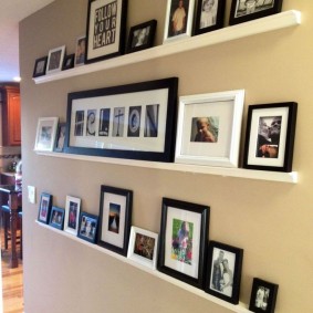 วางภาพถ่ายบนชั้นวางของบนผนัง