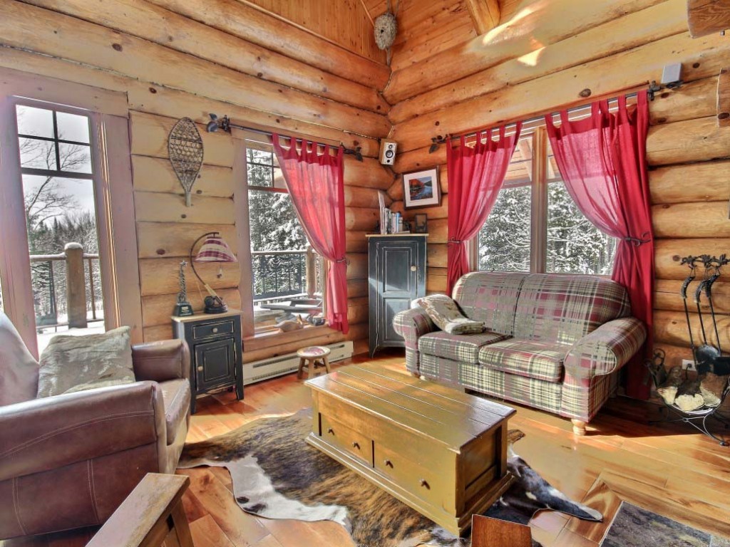 Rideaux roses sur les fenêtres d'une cabane en rondins