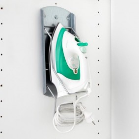 Rangement du fer à l'intérieur de l'armoire dans le couloir