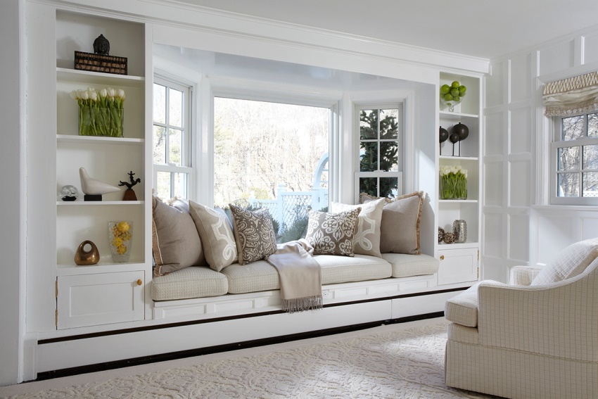 Comfortable sofa between the cabinets in the bay window
