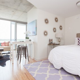 Un petit tapis devant le lit à Odnushka