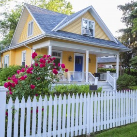 Clôture blanche dans le jardin avant d'une maison de village