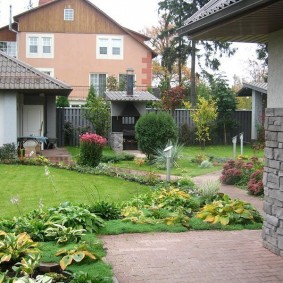 Hôte de buissons dans le parterre de fleurs près de la maison