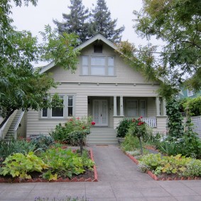 Parterres de fleurs en brique devant une maison de campagne