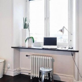 Radiator putih di bawah tetingkap kanak-kanak