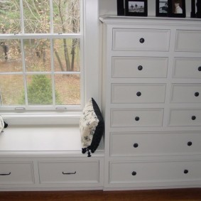 White chest of drawers by the window of the living room